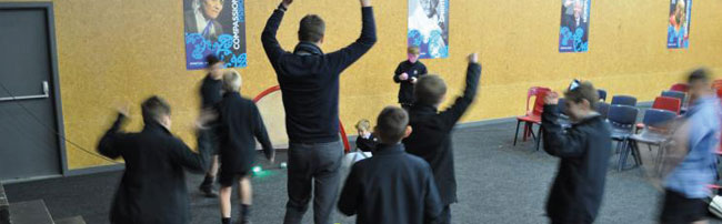 Students and teacher dancing with arms raised