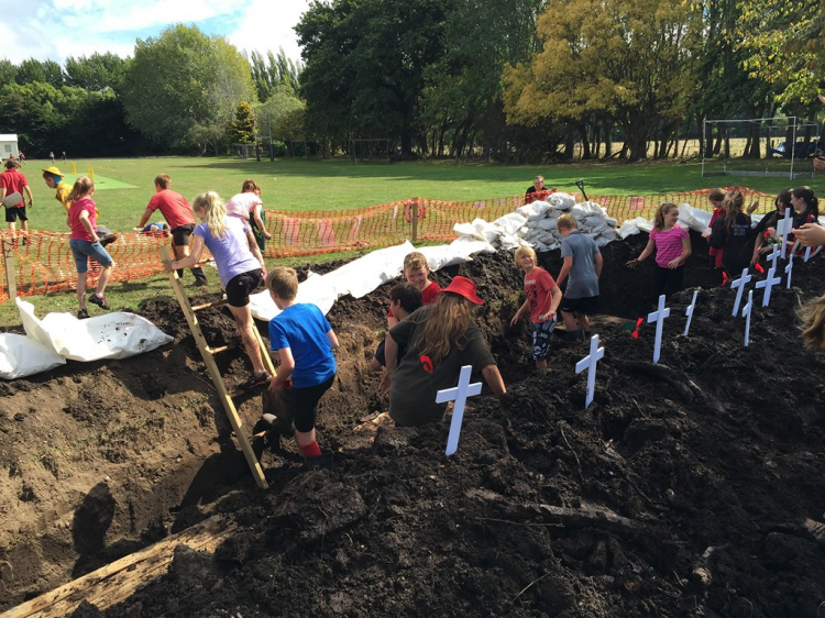 Students climbing in trenches they have dug