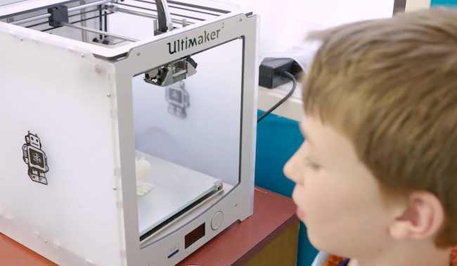 Student looking at 3D printer.