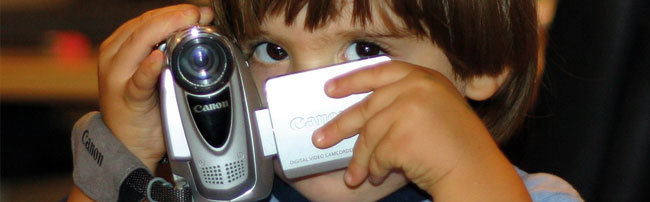 A small child filming with a digital camera
