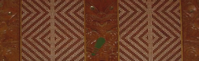 Tukutuku panel and carvings on a wall