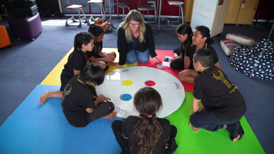 Students working on an activity on the floor with the teacher